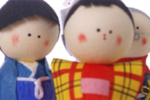 Des poupées en papier, l'une porte un kimono jaune et rouge l'autre un bleu